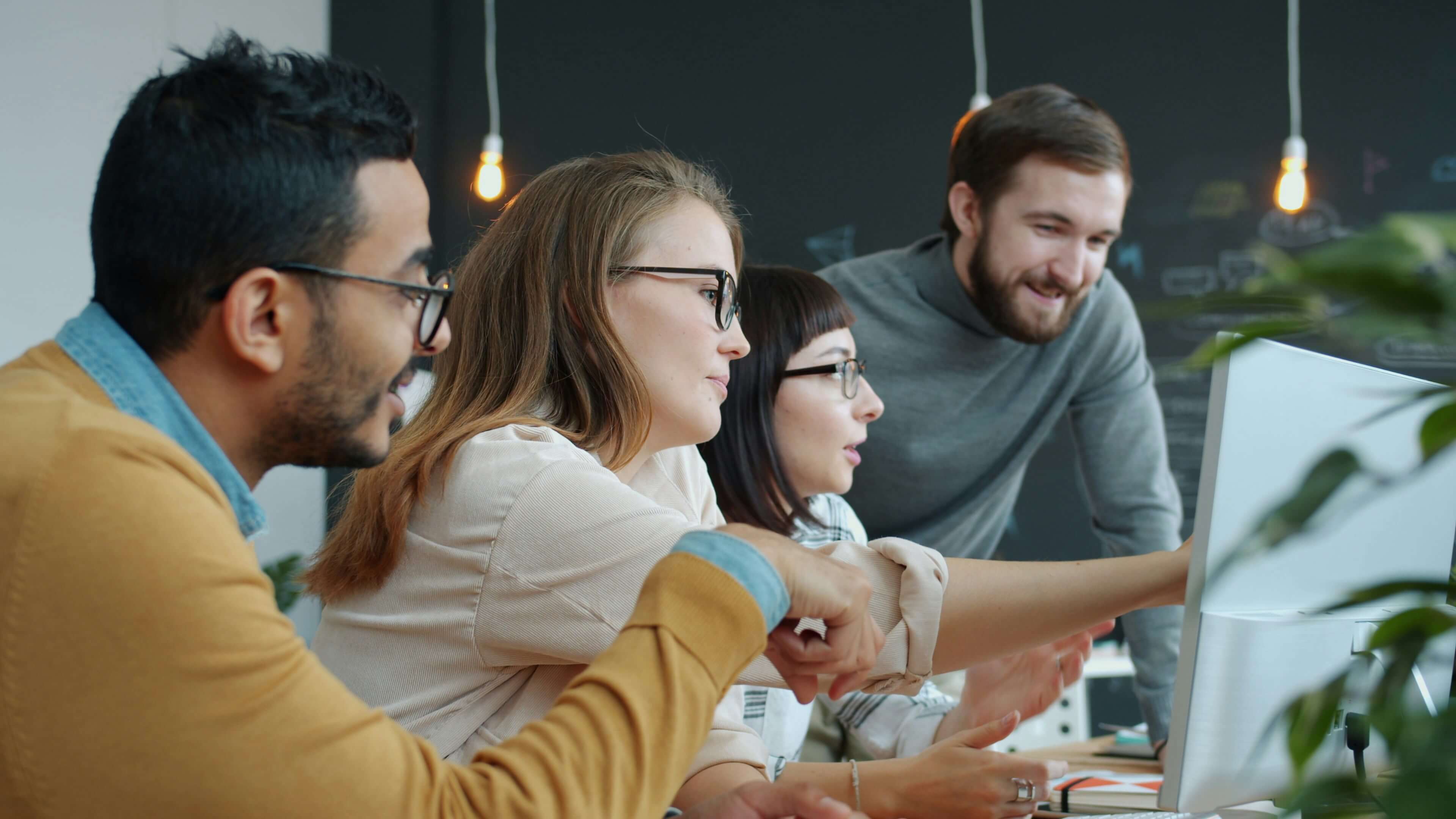 a-diverse-team-collaborating-around-a-computer-screen